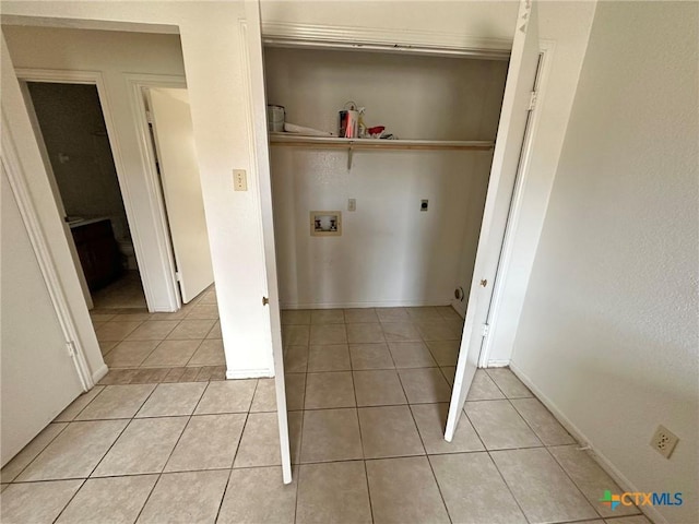 washroom with light tile patterned floors, laundry area, washer hookup, baseboards, and electric dryer hookup