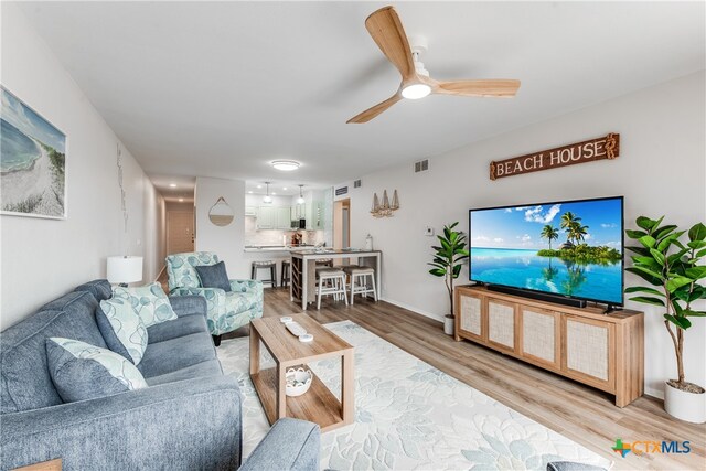 living room featuring ceiling fan and wood-type flooring