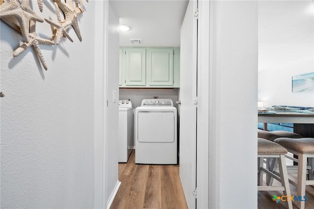 5973 State Highway 361 Unit 125, Port Aransas, TX 78373 - laundry area featuring cabinet space, separate washer and dryer, and wood finished floors
