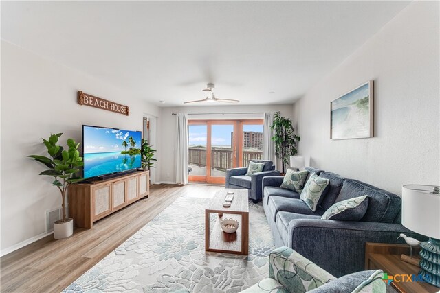 living room with light hardwood / wood-style floors and ceiling fan