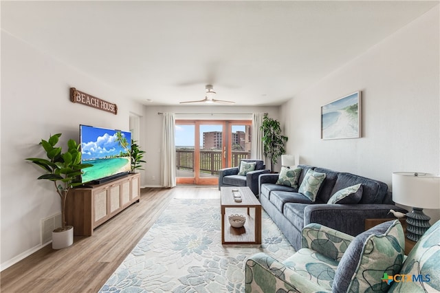 living room featuring ceiling fan and light hardwood / wood-style floors