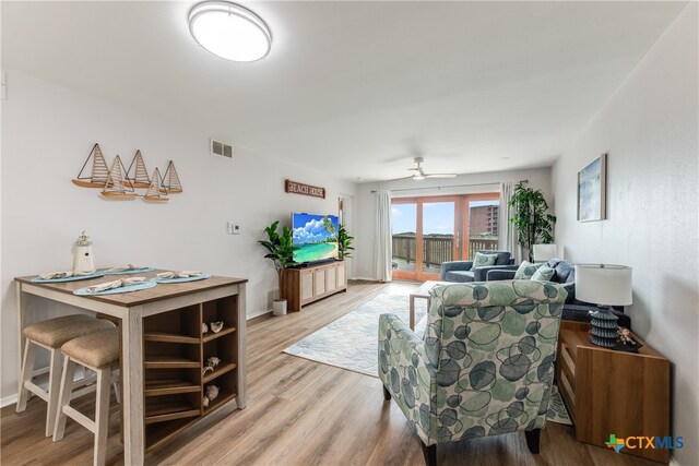 living room with ceiling fan and light wood-type flooring