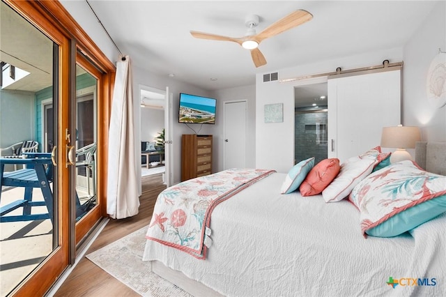 5973 State Highway 361 Unit 125, Port Aransas, TX 78373 - bedroom with wood finished floors, a barn door, and a ceiling fan