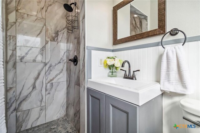 211 Balboa Dr, Universal City, TX 78148 - bathroom with a marble finish shower, vanity, and a wainscoted wall