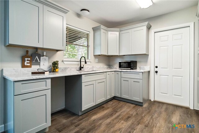 211 Balboa Dr, Universal City, TX 78148 - kitchen with dark wood-style floors, gray cabinets, and light stone countertops