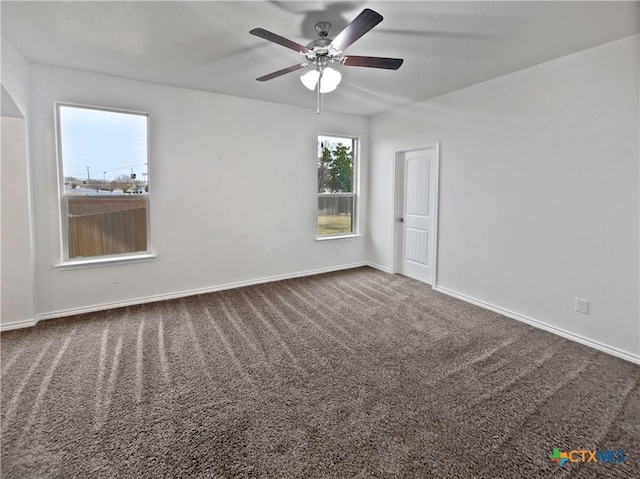 carpeted spare room featuring ceiling fan