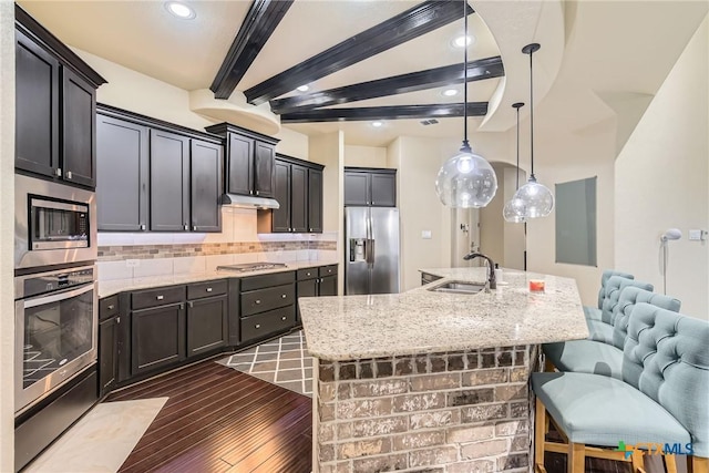 kitchen featuring appliances with stainless steel finishes, dark hardwood / wood-style flooring, sink, beamed ceiling, and hanging light fixtures