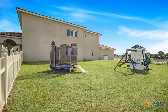3 Sago Dr, Port Lavaca, TX 77979 - rear view of property featuring a trampoline, a playground, and stucco siding