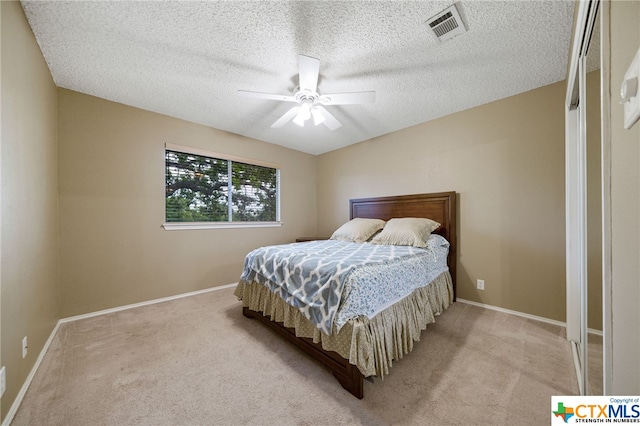 carpeted bedroom with a textured ceiling and ceiling fan