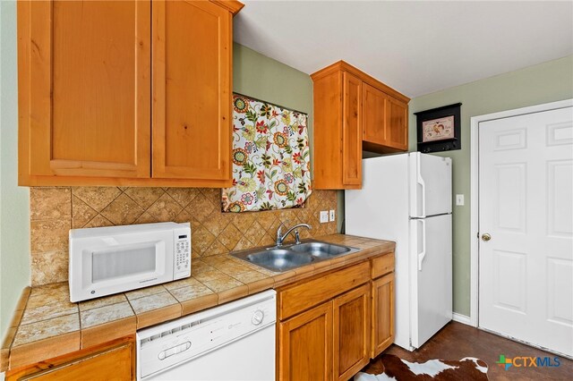 kitchen featuring white appliances, tile countertops, tasteful backsplash, and sink