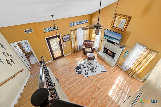 living room with hardwood / wood-style flooring, high vaulted ceiling, and ceiling fan