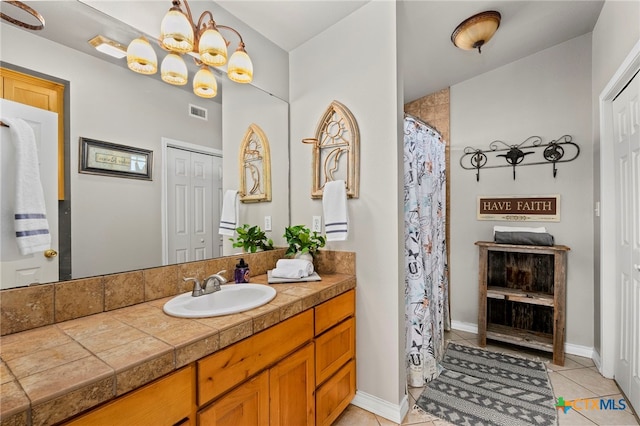 bathroom with vanity, tile patterned floors, and a notable chandelier