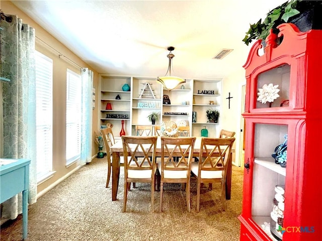 carpeted dining area featuring visible vents