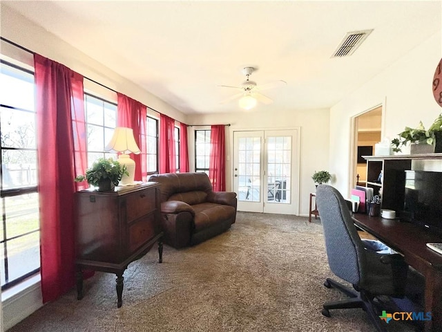 carpeted office space with a ceiling fan and visible vents