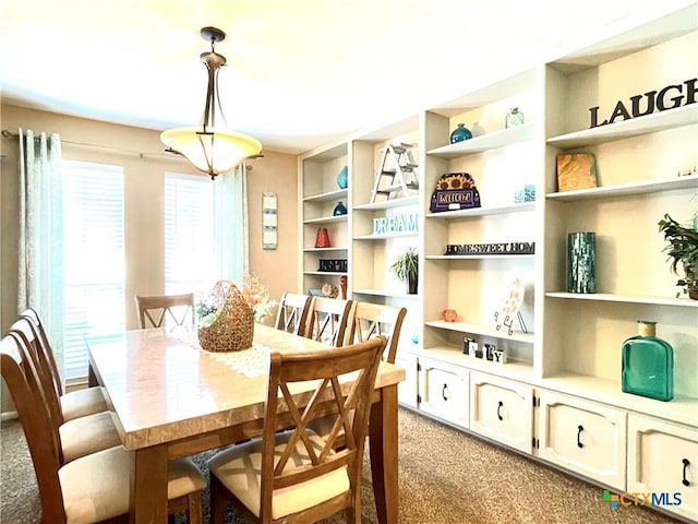 dining room featuring built in features and light carpet