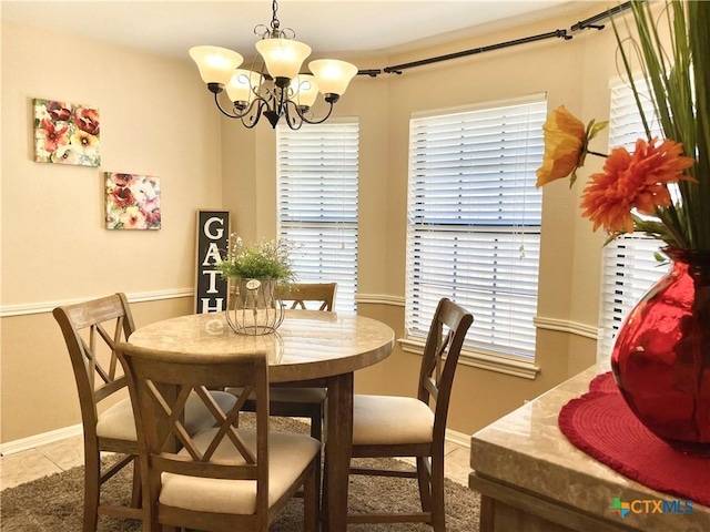 dining room with light tile patterned floors, baseboards, and a notable chandelier