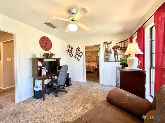 office area featuring carpet flooring, baseboards, visible vents, and ceiling fan