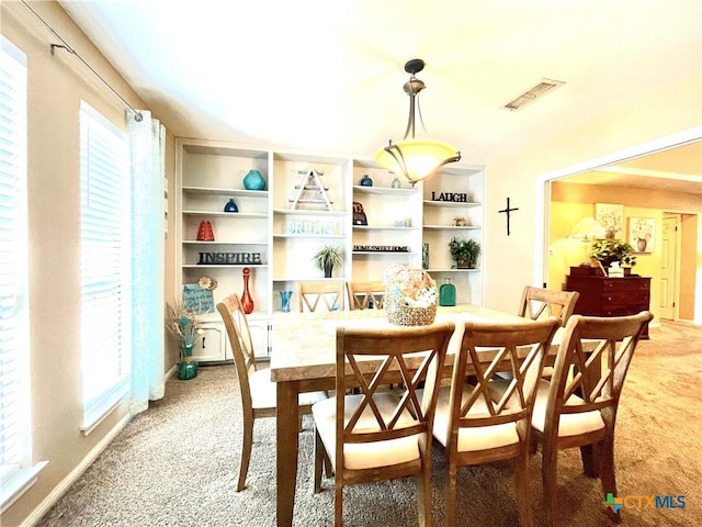 dining room featuring visible vents and light carpet