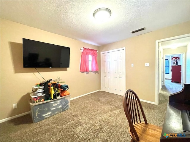 carpeted office with baseboards, visible vents, and a textured ceiling