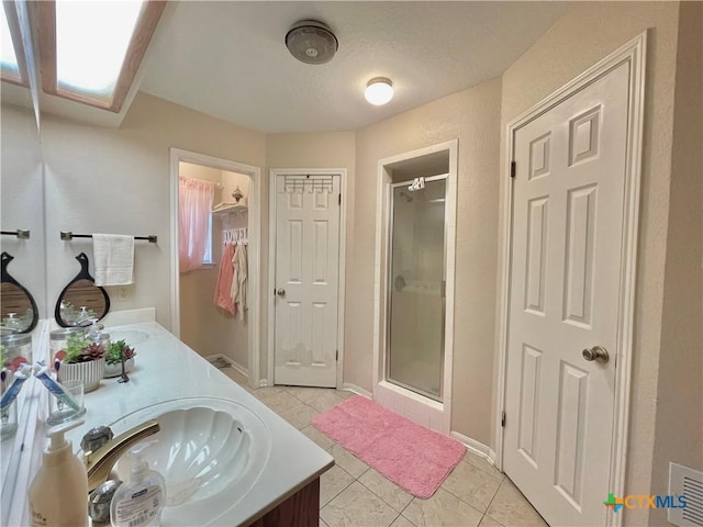 full bath with tile patterned floors, a stall shower, and a sink