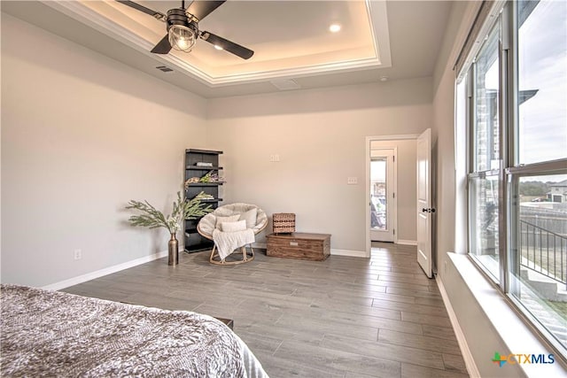 bedroom with ceiling fan, a tray ceiling, and access to outside