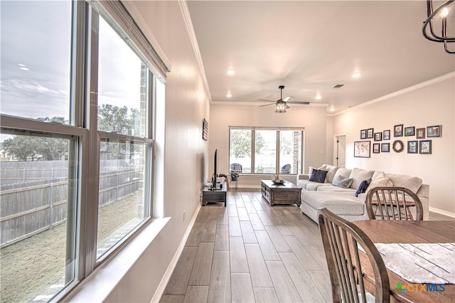 living room featuring crown molding and ceiling fan