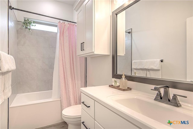 full bathroom featuring shower / tub combo with curtain, vanity, and toilet