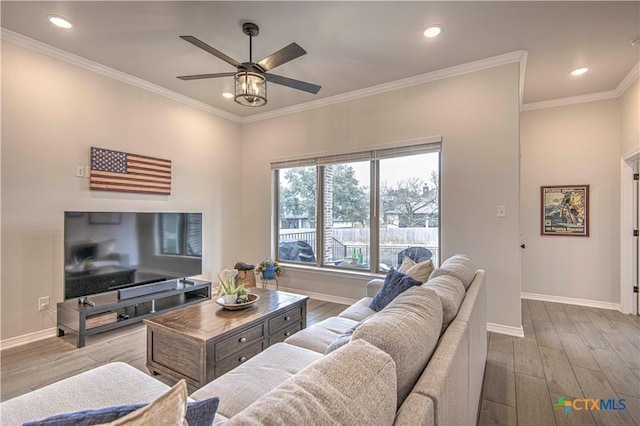 living room with crown molding, ceiling fan, and light hardwood / wood-style flooring