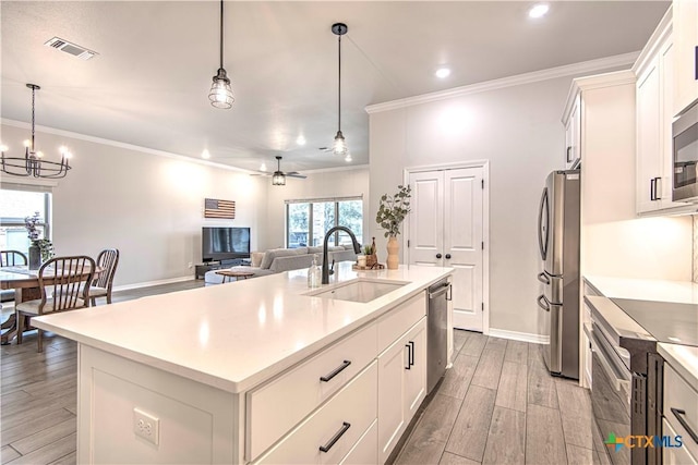 kitchen featuring stainless steel appliances, sink, a center island with sink, and white cabinets