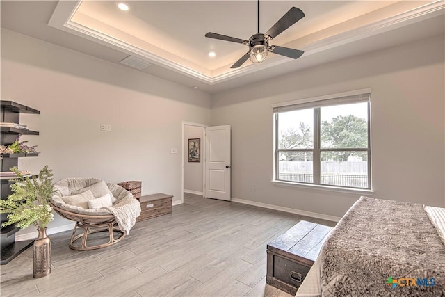 living area featuring a tray ceiling, light hardwood / wood-style flooring, and ceiling fan