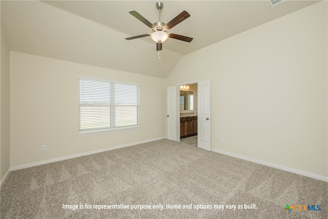 unfurnished bedroom with ensuite bath, light carpet, ceiling fan, and vaulted ceiling