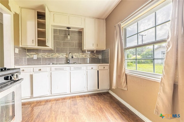 123 Burnet St, Port Lavaca, TX 77979 - kitchen with range, light countertops, decorative backsplash, light wood-style flooring, and baseboards