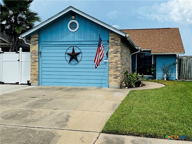 view of front of home with a front yard and a garage