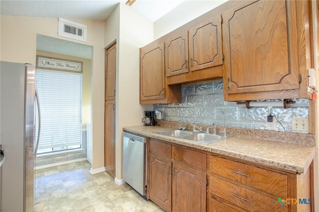 505 Cabana Dr, Victoria, TX 77901 - kitchen featuring appliances with stainless steel finishes, decorative backsplash, light countertops, and brown cabinetry