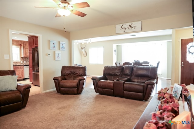 living room with a wealth of natural light, light carpet, and ceiling fan