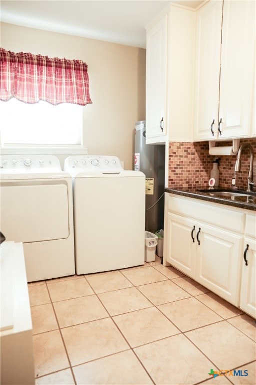 clothes washing area with sink, cabinets, washing machine and clothes dryer, and light tile patterned floors