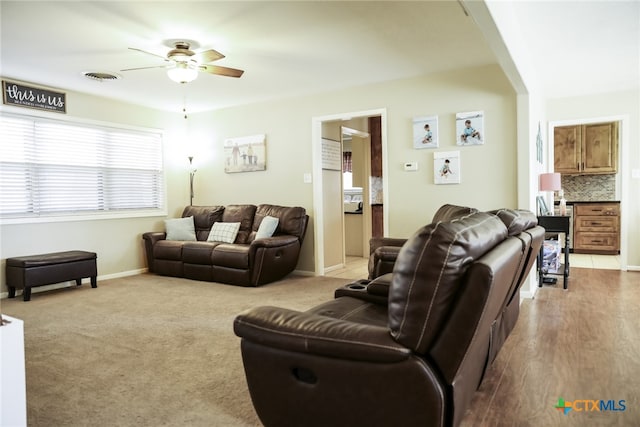 living room with light hardwood / wood-style floors and ceiling fan