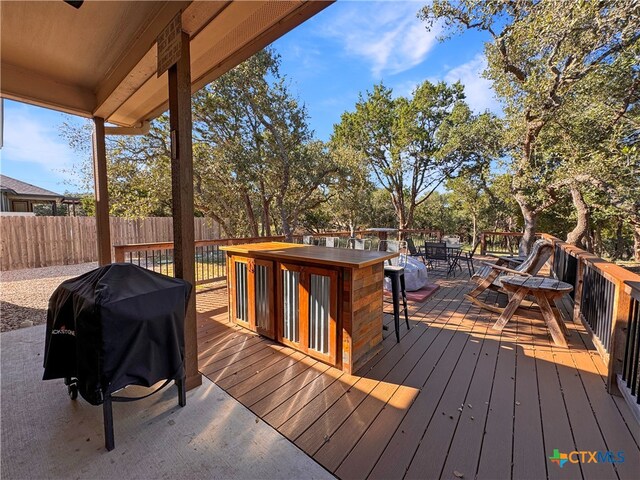 wooden deck featuring a bar and a grill