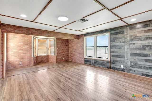 116 N Ben Wilson St, Victoria, TX 77901 - unfurnished living room featuring brick wall and wood finished floors