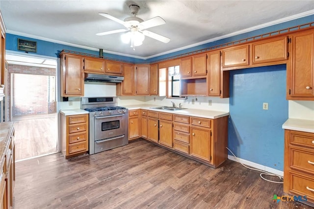 116 N Ben Wilson St, Victoria, TX 77901 - kitchen featuring stainless steel gas stove, under cabinet range hood, brown cabinets, ornamental molding, and dark wood finished floors
