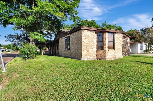 116 N Ben Wilson St, Victoria, TX 77901 - view of property exterior with brick siding and a yard