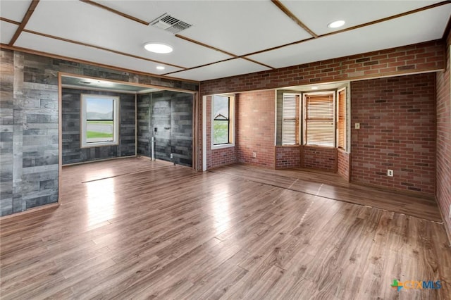 116 N Ben Wilson St, Victoria, TX 77901 - unfurnished living room with plenty of natural light, wood finished floors, and brick wall