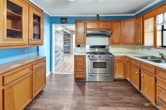 116 N Ben Wilson St, Victoria, TX 77901 - kitchen with gas stove, under cabinet range hood, light countertops, dark wood-style floors, and brown cabinetry