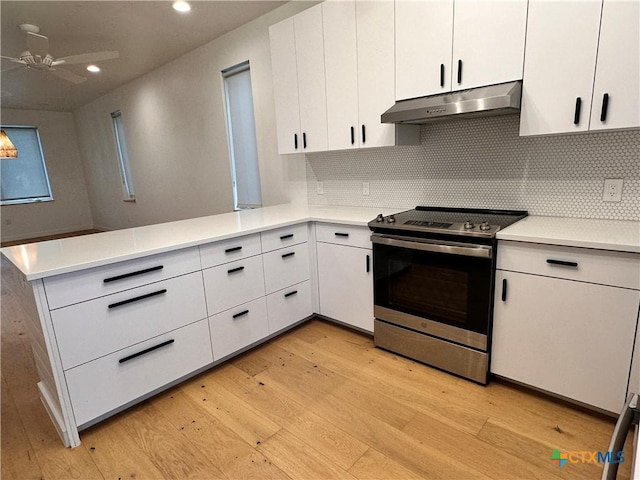 kitchen with backsplash, white cabinetry, stainless steel electric range oven, and kitchen peninsula