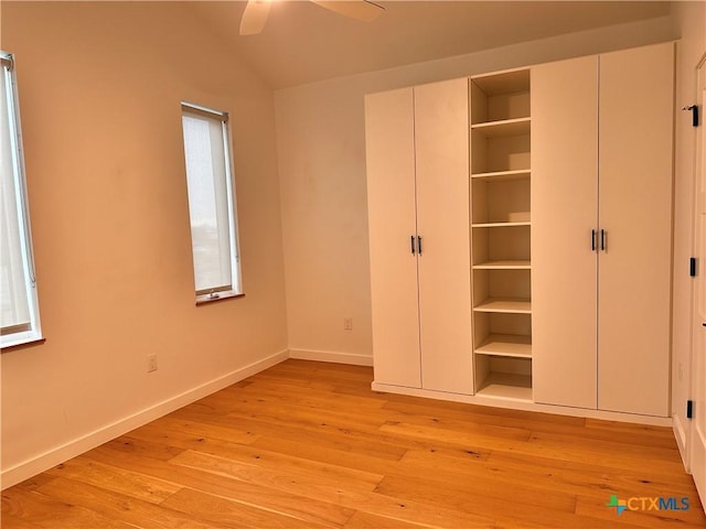 unfurnished bedroom featuring ceiling fan, light hardwood / wood-style floors, and vaulted ceiling