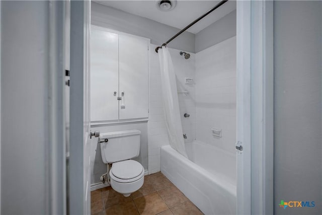 full bath featuring tile patterned floors, shower / bath combination with curtain, and toilet