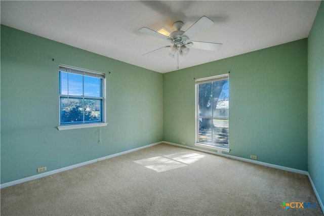 unfurnished room featuring plenty of natural light, carpet, and baseboards