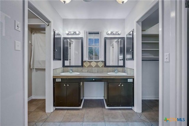 full bathroom featuring double vanity, decorative backsplash, tile patterned flooring, and a sink