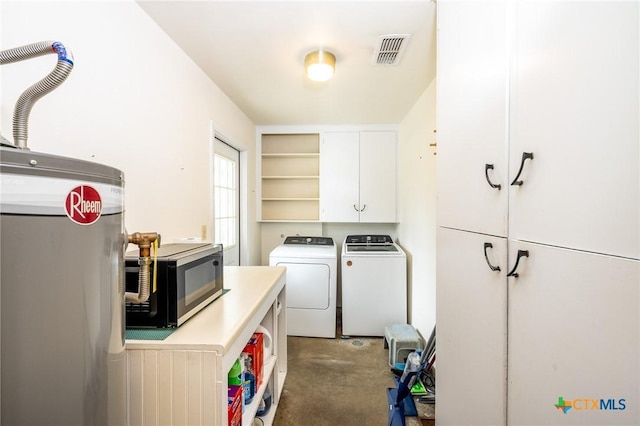 clothes washing area with washer and dryer and cabinets