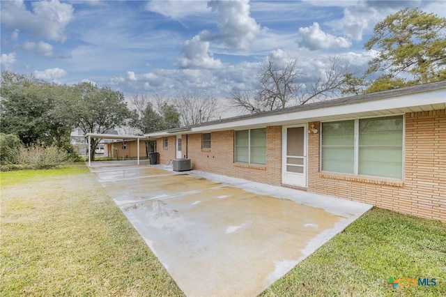 view of front of property with central AC unit, a carport, and a front lawn